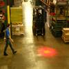 Pedestrian and forklift both approach intersection cautiously because of warning light shining on floor